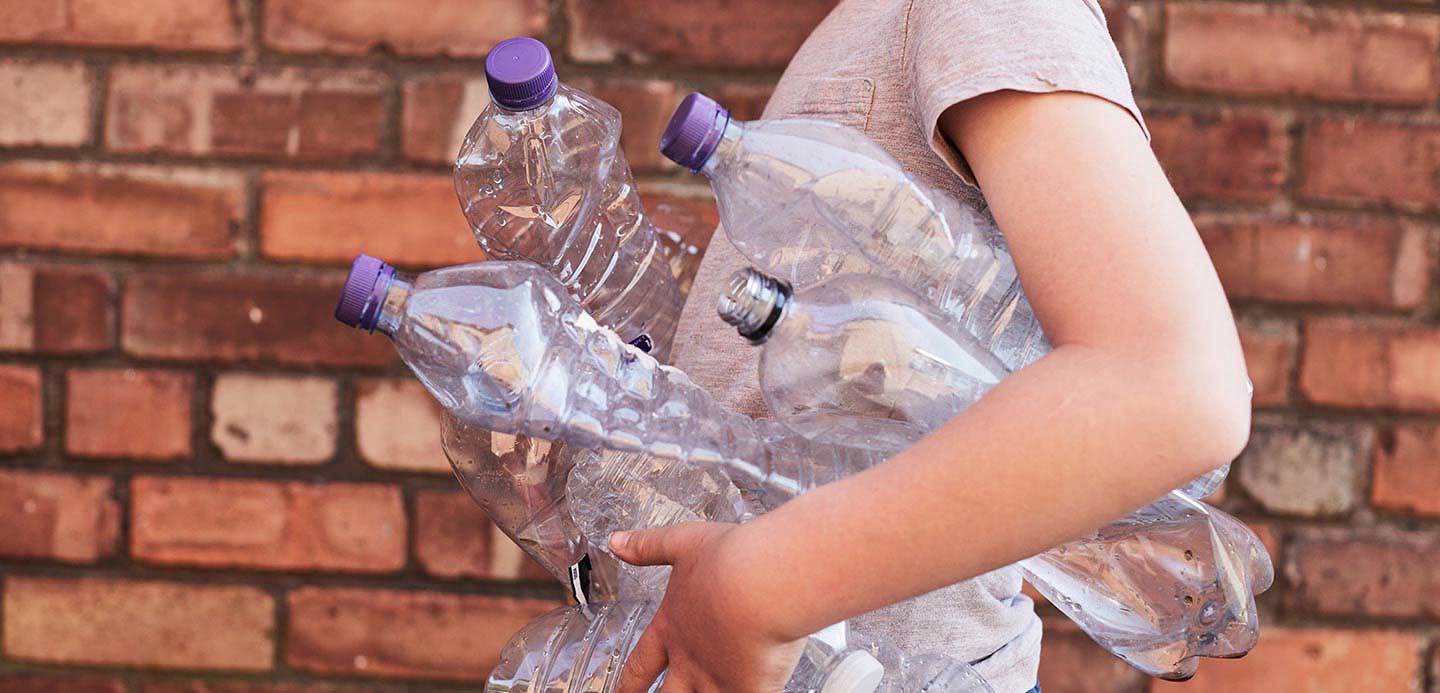 A person carrying plastic bottles for reycling A person carrying plastic bottles for reycling